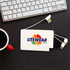 A white power bank with multiple charging cables next to a computer keyboard and a red mug. It has a logo.