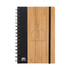 A spiral-bound notebook with a bamboo cover and a dark fabric section, featuring a logo.