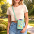 A mint green silicone phone bag with cut-out holes, worn crossbody, featuring floral designs and a strap.