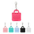 A pink mini bag-shaped keychain with holes and a clip, alongside versions in pastel pink, teal, black, and white.