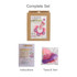 A crochet kit featuring pink and purple yarn, floral embellishments, and instructions in a cardboard packaging.