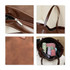 A brown suede leather tote bag with a zip closure and various items inside, including pastel-coloured accessories.