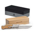 A stainless steel pocket knife with a wooden handle, displayed next to a sleek black and natural wooden box.
