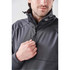 A men's anorak jacket in grey with a high collar and zip. The model is adjusting the zipper.