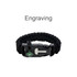 A black survival bracelet featuring a compass and buckle, made from durable woven material. It includes a logo.