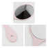 A pink handheld makeup mirror with an oval reflective surface and a looped handle. The design is chic and compact.
