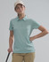 A woman wearing a light blue polo shirt and a beige cap stands with a golf club in hand. The image features a logo on the shirt.