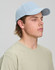 A light blue jacquard texture 5 panel cap worn by a young man with short hair and a beige t-shirt.