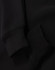A black unisex premium fleece oversized hoodie with ribbed cuffs. The fabric appears soft and cozy.