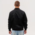A black bomber jacket viewed from the back, featuring a simple design and ribbed cuffs.