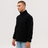 A man stands wearing a black polar fleece full zip jacket, featuring a zip closure and side pockets.