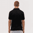 A black polo shirt displayed on a model from the back, featuring short sleeves and a collar.