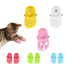 A collection of pet clog slides in yellow, white, pink with a unicorn design, and green, alongside a cat.