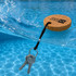 A round cork keyring floats on water, attached to a keychain with metal keys, against a blue pool background.