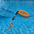 An oval cork keyring in natural colour with a black strap, holding two metallic keys, partially submerged in water.