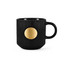 A black ceramic mug features a textured surface and a bronze medal accent on the front. It has a sturdy handle and a rounded base.