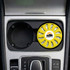 A round, yellow air freshener is placed in a car cup holder, featuring a logo and a vented design.