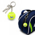 A bright yellow tennis ball keyring attached to a chain and a set of keys, alongside a blue sports bag.