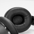 A close-up of black cushioned ear cups of wireless headphones, featuring smooth material and a sleek design.