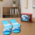 A retro TV-style gift box in red with a pair of blue and white wave-patterned socks beside it on a wooden surface.