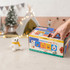 A colourful multi-compartment box with various playful emoji designs and a small white teddy bear beside it.
