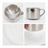 A stainless steel coffee mug with a mirror finish, featuring a handle, displayed on a white plate.