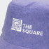 A purple reversible bucket hat with a textured finish and a logo embroidered on the front.
