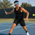 A man in a black tank top and shorts plays tennis, wearing a colourful mesh headband while preparing to hit a tennis ball.