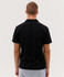 A black polo shirt with a simple design, viewed from the back, featuring short sleeves and a collar.