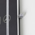 A black A5 notebook with a silver elastic band and a logo on the cover.
