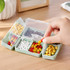 A folding pills box in green with seven compartments, holding various types and colours of pills.