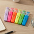 A set of six highlighters in purple, pink, orange, yellow-green, green, and blue, featuring a logo on the side.