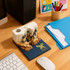 A 3D paper carving notepad in cream and navy, featuring intricate castle designs, placed on a wooden desk with office supplies.