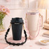 A drink bottle set featuring a black tumbler and a pink flower strap with a cream tumbler, both with logos.