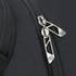 A close-up of a black backpack featuring dual silver zippers and a textured surface. The bag includes branding.