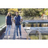 A navy blue unisex puffer vest displayed on two models by a waterfront. The vest features a logo.