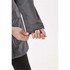 A close-up of a person's hand adjusting the cuff of a grey jacket with a logo.