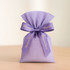 A purple satin ribbon tied around a lavender fabric bag with a branding logo.