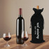 A drink bottle bag in black flannel, designed for wine, with a vineyard logo. Two wine glasses with red wine are beside it.