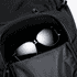 A black backpack with a zippered pocket containing a pair of dark sunglasses inside.
