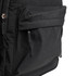 A black backpack with a front pocket and zipper details, featuring a simple, functional design and a logo.