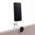 A silver phone holder with a black circular base, securely attached to a surface, holding a smartphone.