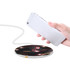 A wireless charger featuring a sleek black design with flowing red and white patterns, accompanied by a mobile phone.