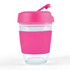 A reusable coffee cup with a clear body and a bright pink silicone sleeve and flip lid.