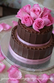 Chocolate wedding cake with pink accents.