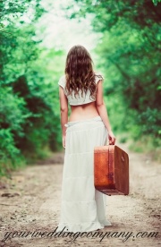 Bride walking with suitcase.