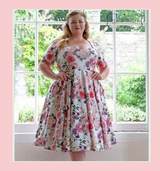 1950s vintage inspired full circle dress by Cerys' Closet. Made in the UK. Dress can be worn with or without the petticoat. Has a 4 panel full circle skirt with seam pockets, a sweetheart neckline and sleeves.

Stunning white background with floral print, ideal as an alternative wedding dress, wedding guest dress and bridesmaid  dress. 
