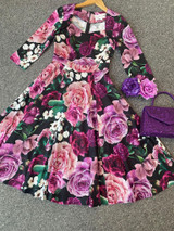 Vintage 1950s Inspired Purple, Pink and Black Floral Swing Dress with 3/4 Sleeves and Sweetheart Neckline by Cerys' Closet. A mixture of beautiful purple, burgundy, light purple, pink and white flowers with green foliage. Available in sizes 8 to 26