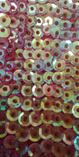 A long handmade sequin dress, in 8mm cupped iridescent red, orange and pale green sequins close up view
