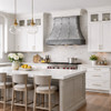 Handcrafted wrought iron range hood with riveted strap design in a transitional style kitchen